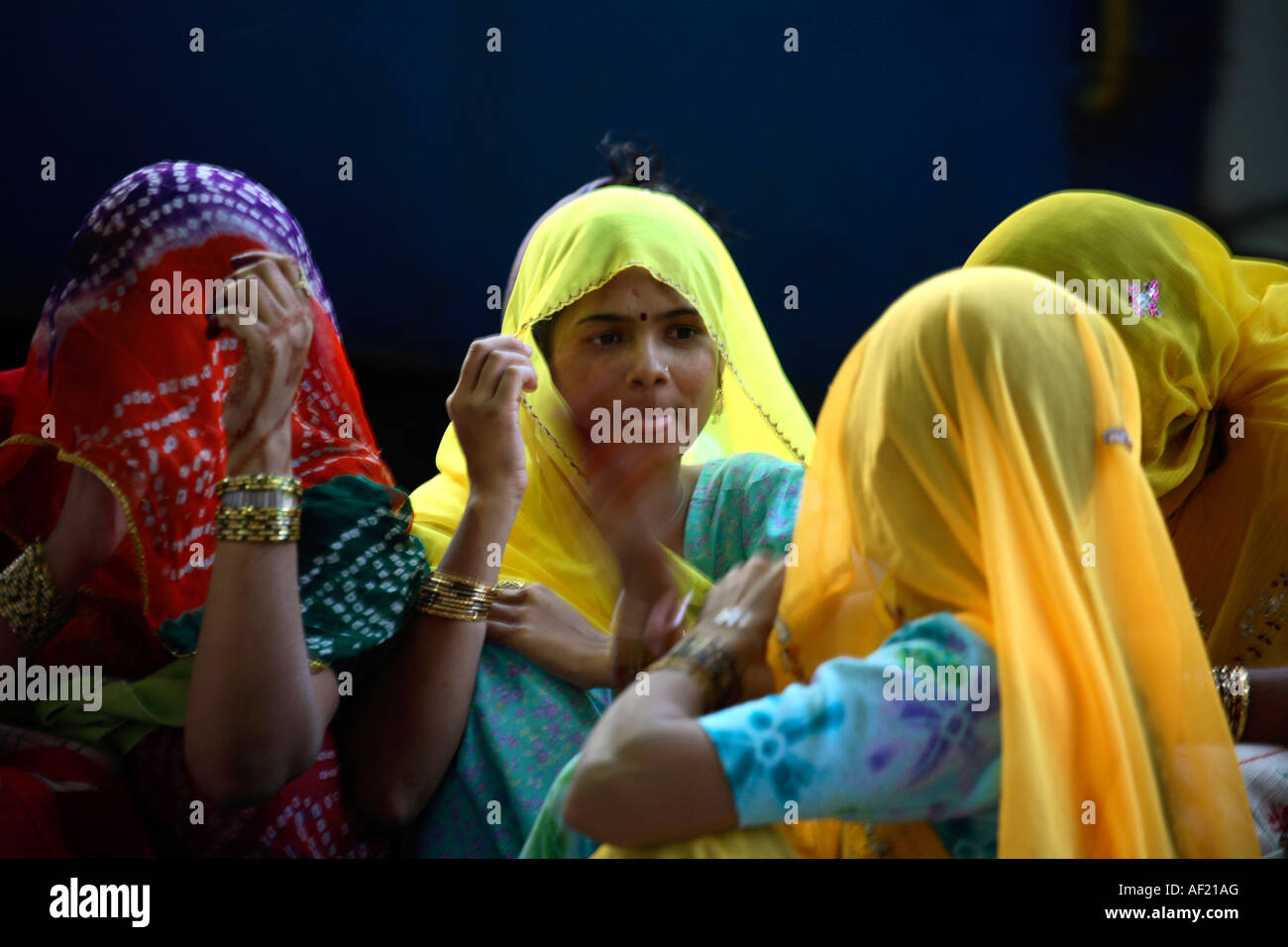 Junge indische Weibchen mit Köpfen bedeckt warten auf Pune Bahnhof, Maharashtra, Indien Stockfoto