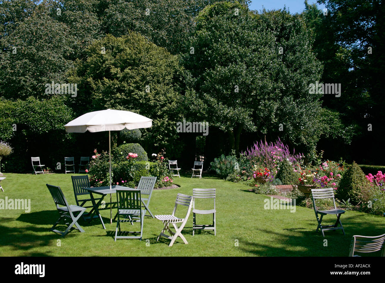 Tische und Stühle im malerischen traditionellen englischen Cottage Garden im St Mary's House, Bramber, West Sussex, England Stockfoto