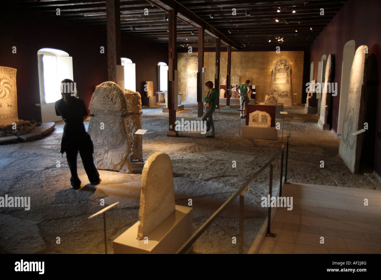 Touristen auf der Suche auf geschnitzten Steinen im Museum Gotlands Fornsal in Visby Gotland Schweden Stockfoto