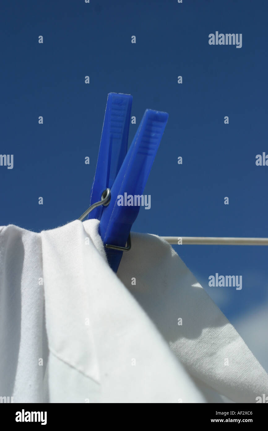 blaue Wäscheklammer auf weißen Blatt mit Wäscheleine Stockfoto