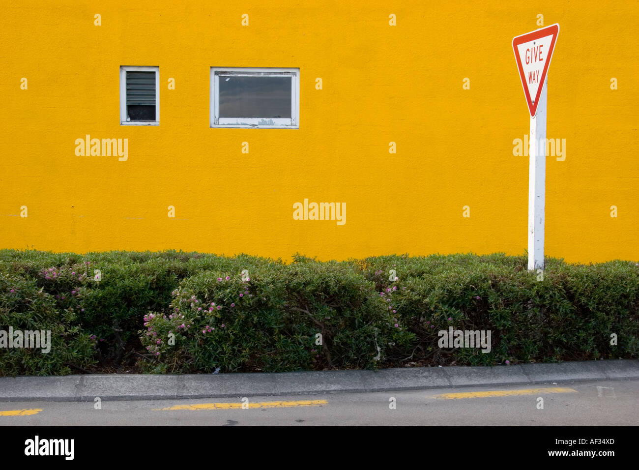 Weg-Zeichen vor der gelben Wand zu geben Stockfoto