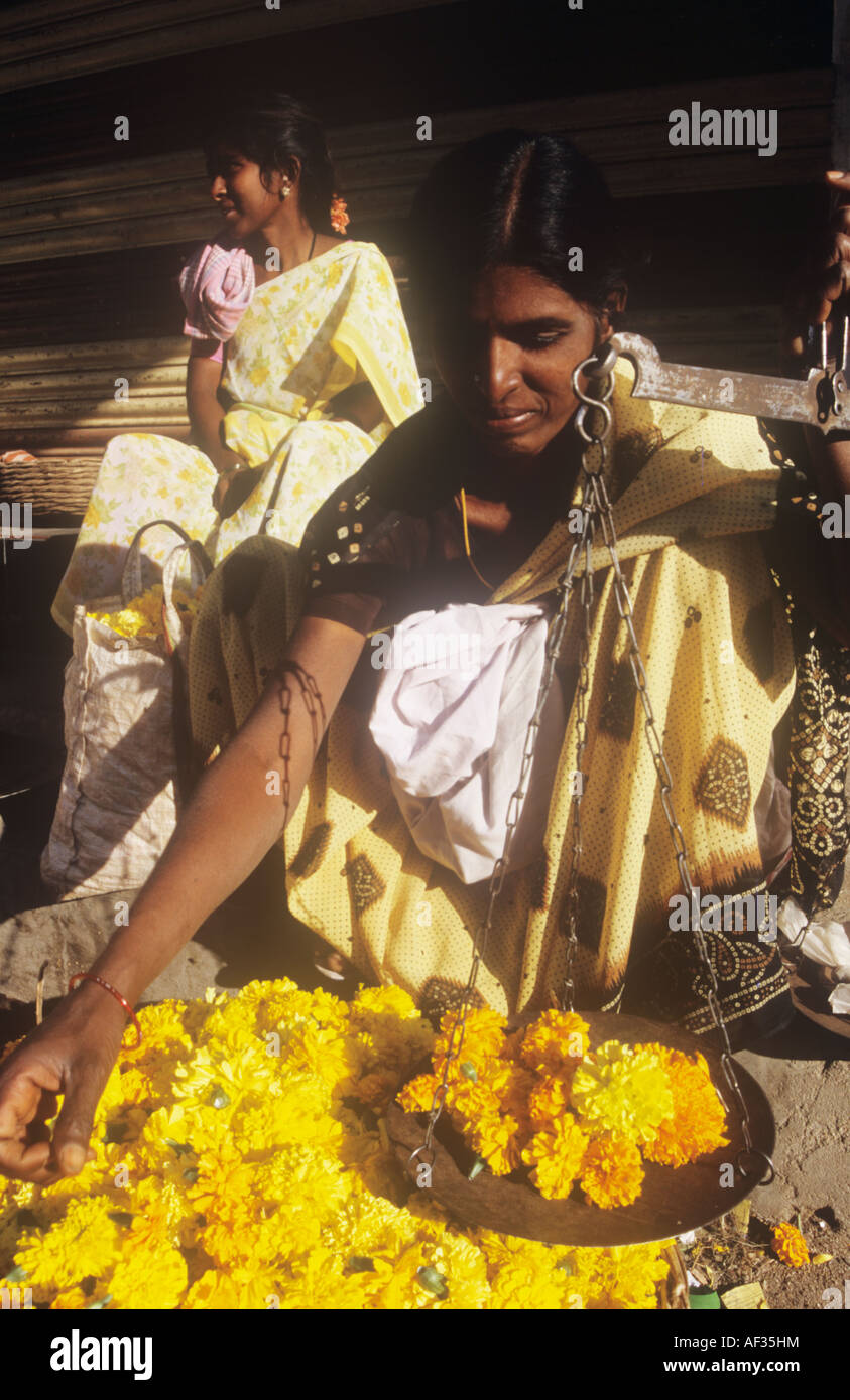 Eine Frau wiegt, Ringelblumen zum Verkauf auf der Straße in der Nähe von den Ashram von Sai Baba. Stockfoto