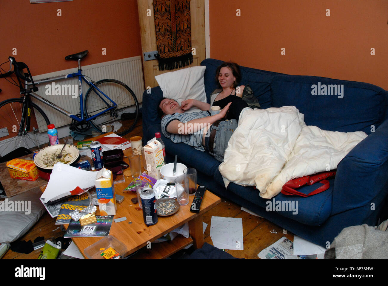Junges Paar schläft auf Sofa in studentischen Unterkünften. Stockfoto