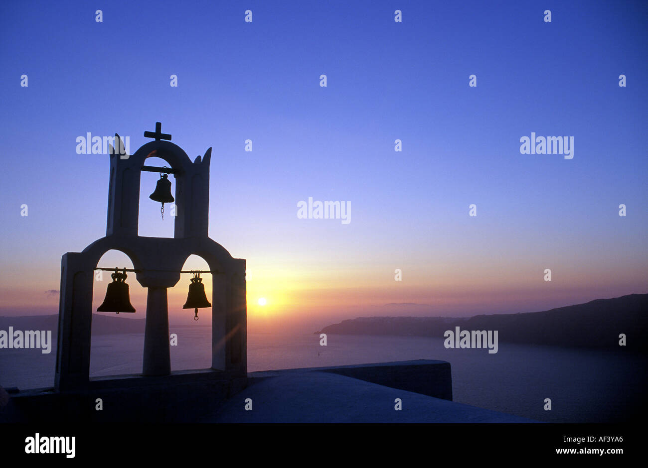 3 Glocken auf Kirche bei Sonnenuntergang in der Silhouette, Santorin Stockfoto