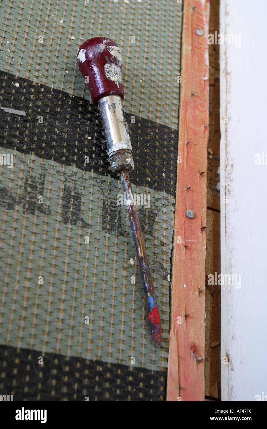 DIY-Schraubendreher Werkzeug neben Teppichunterlage und Holzlatte Stockfoto