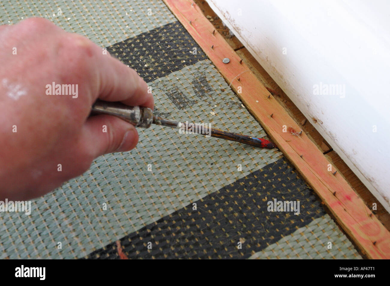 DIY mit einem Schraubenzieher anheben und entfernen Teppich Unterlage Batten von skirtingboard Stockfoto