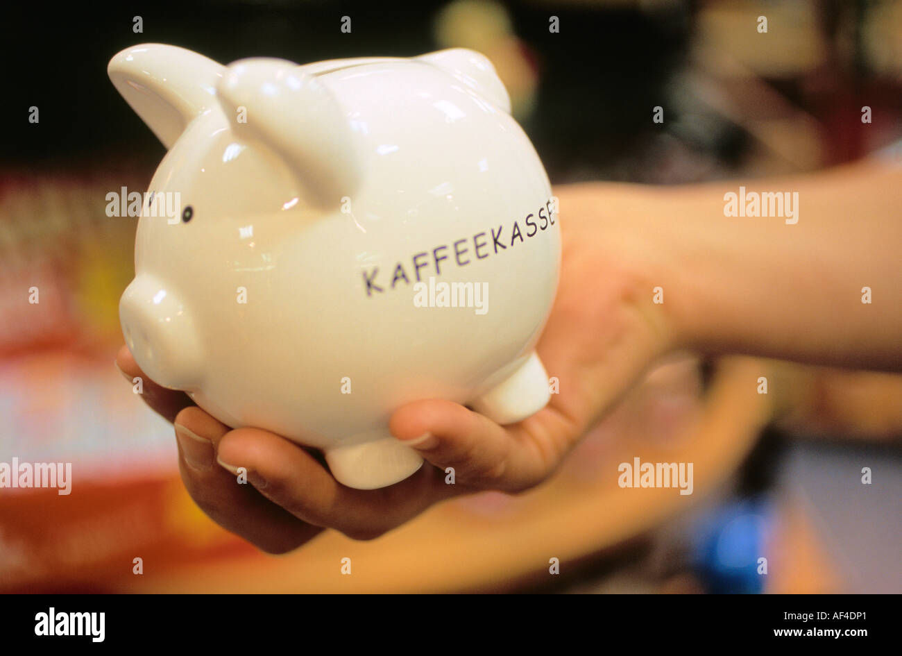 Frau Hand hält ein Sparschwein mit dem Schriftzug Kaffeekasse Kaffee Kasse  Stockfotografie - Alamy