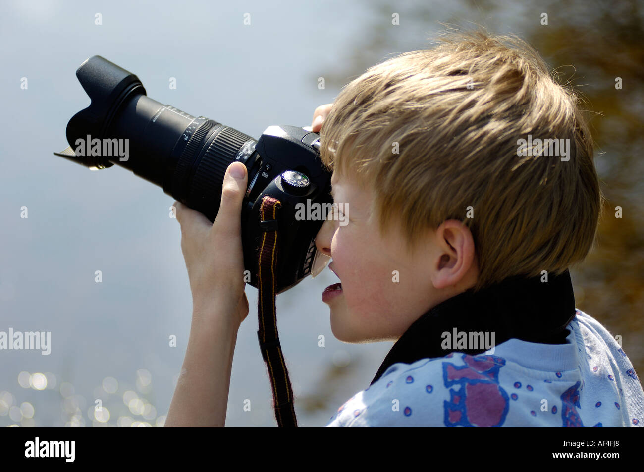 10 Jahre alter Junge mit Spiegelreflex-Kamera fotografieren Stockfoto