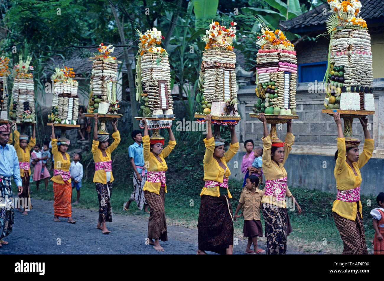 Straßenprozession von Frauen, die Angebote von Lebensmitteln auf dem Kopf für die Götter in Batubulan Village Insel Bali Indonesien Stockfoto