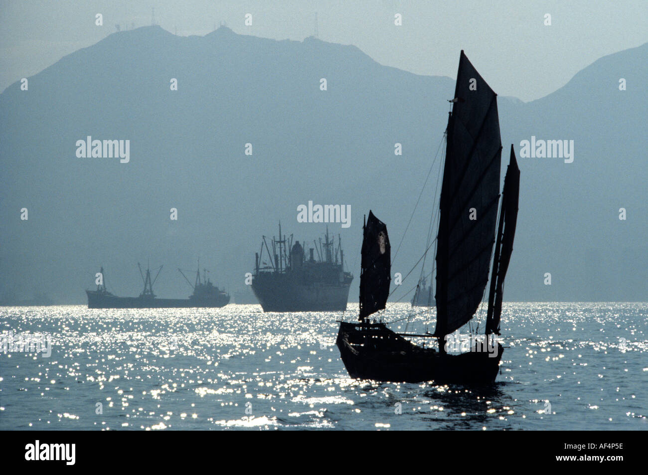 Traditionelles chinesisches Segeln Trödel Ende 1970's auf nebligen Meer Sonne funkelnden Wasser im Victoria Harbour Hong Kong China Stockfoto
