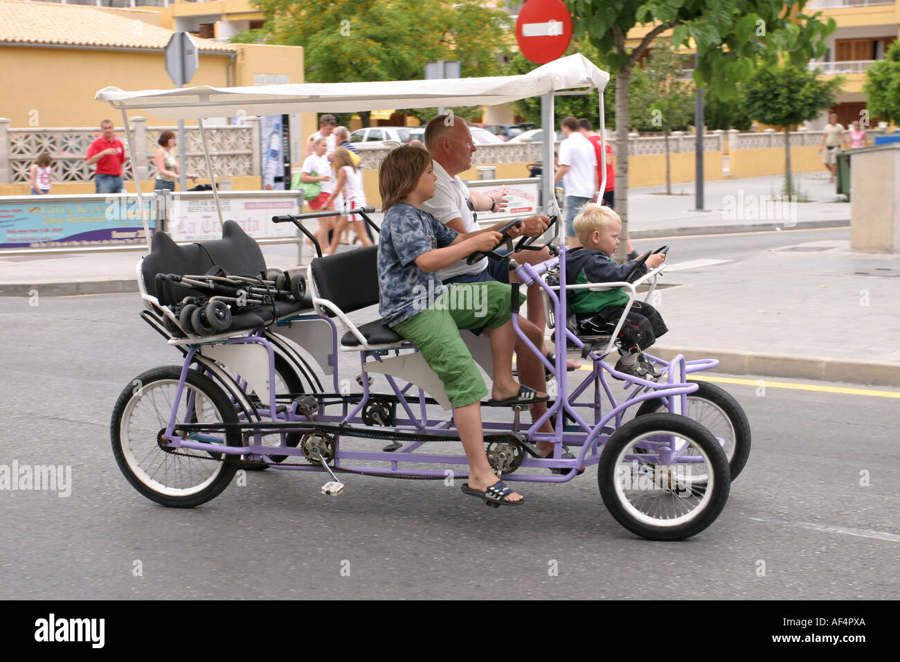 Touristen, die mit dem vier-Rad-Fahrrad in Alcudia Mallorca Spanien  Stockfotografie - Alamy