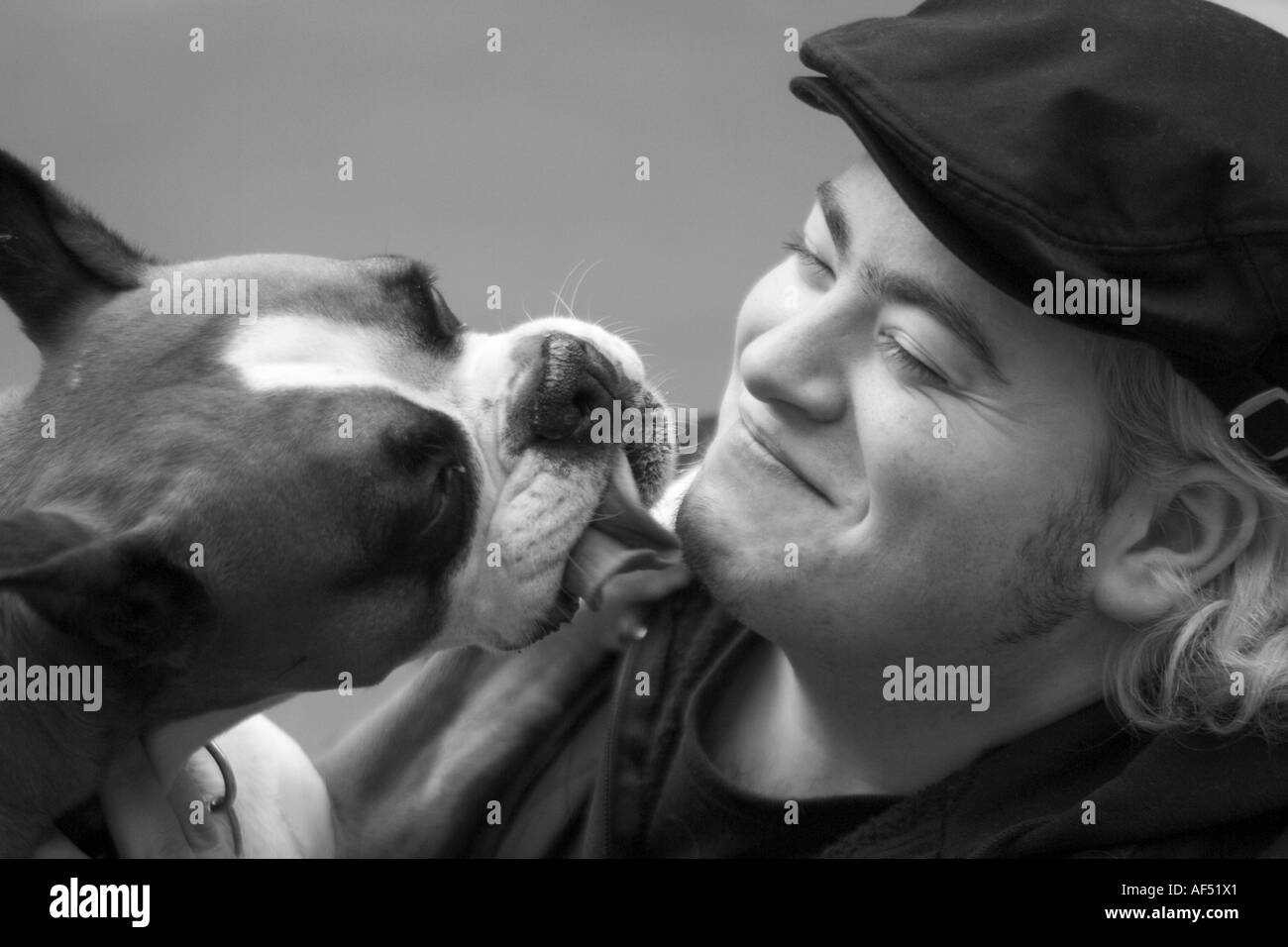 Nahaufnahme von einem Hund lecken Gesicht eines jungen Mannes Stockfoto