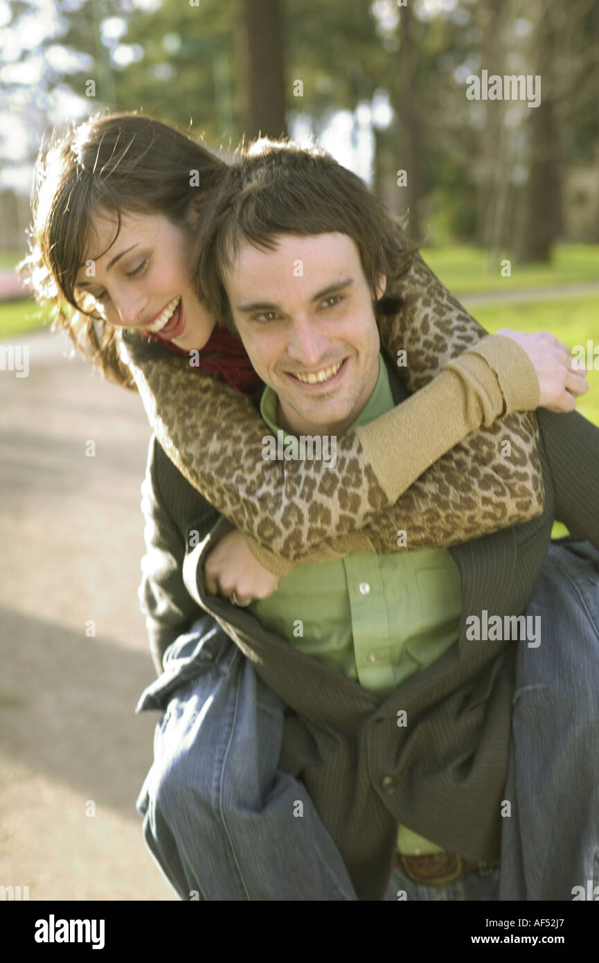 Junge Frau Reiten Huckepack auf einem jungen Mann Stockfoto