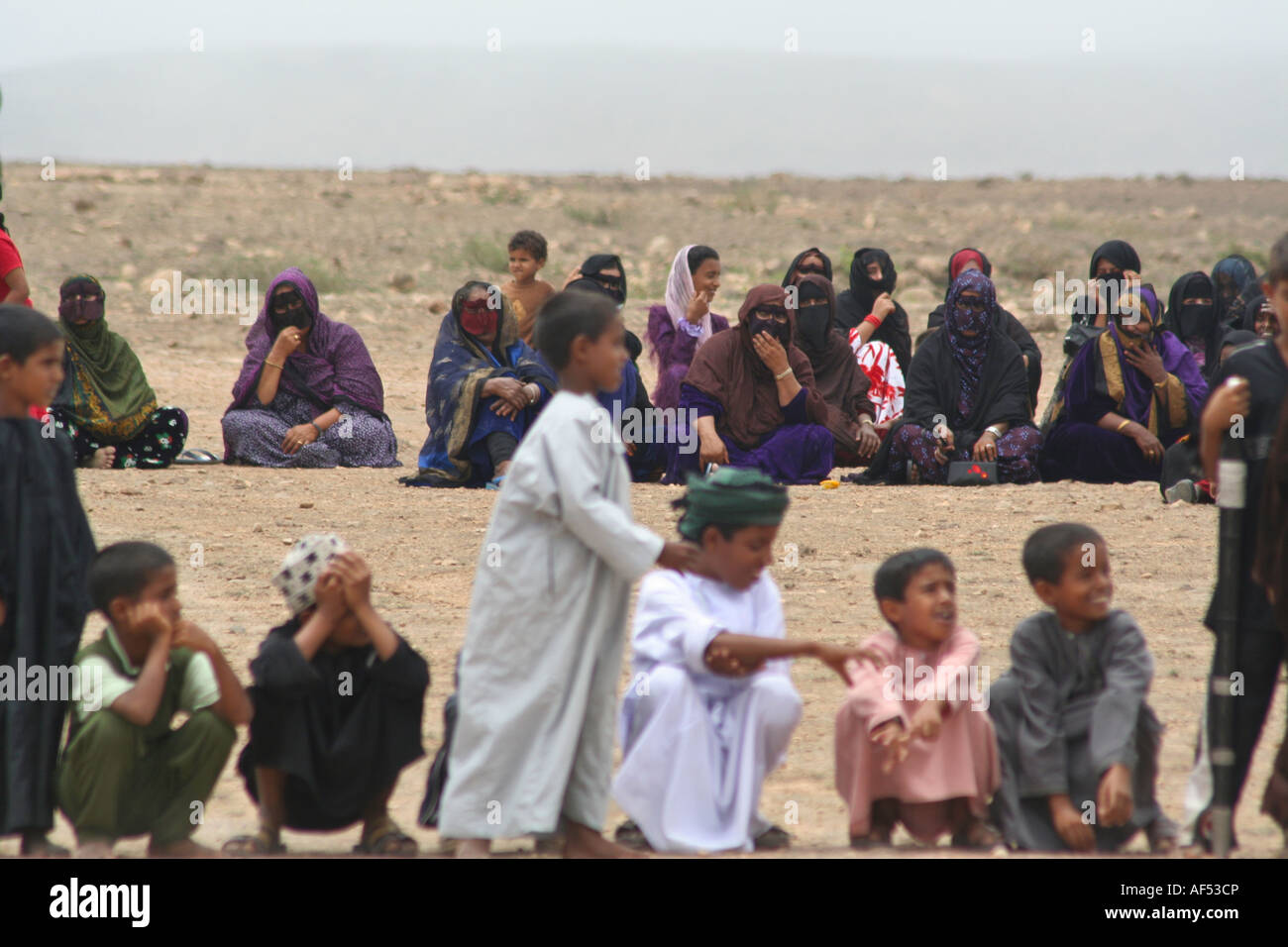 Kinder und Frauen sitzen Reihen von der Kreis bei einer Feier, lokalen Stamm feiert während Kharif, Salalah, Oman Stockfoto
