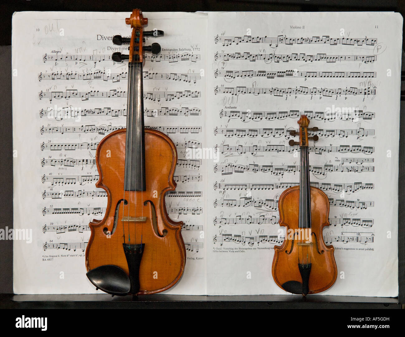 Still life: 2 Miniatur Geigen in der Partitur (Divertimento in F-Dur, KV 138 / 125 c (Mozart, Wolfgang Amadeus)) offen, mit Anmerkungen in Bleistift. Stockfoto