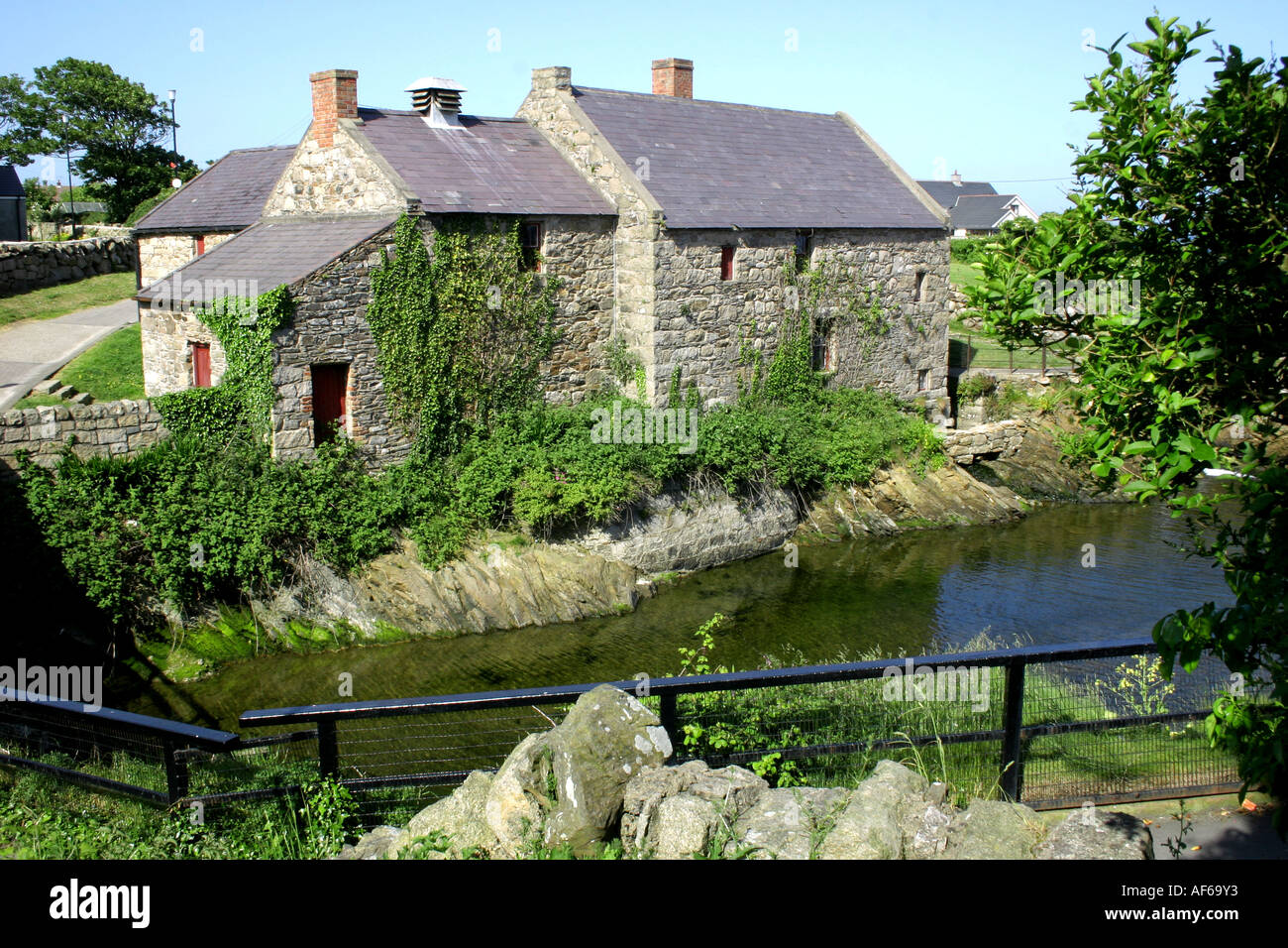 Annalong Fluss fließt vorbei an der alten Kornmühle in Annalong, County Down, Nordirland Stockfoto