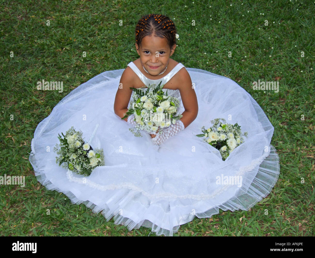 Eine junge Brautjungfer sitzen auf Rasen Stockfoto