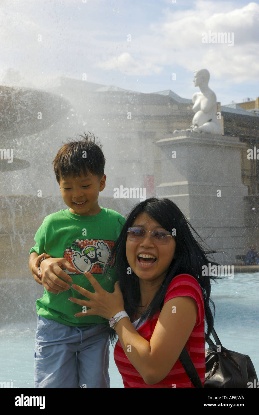 Touristen genießen Sonne vor dem Brunnen und Skulptur Statue Alison Lapper schwanger am Trafalgar Square, London, UK Stockfoto