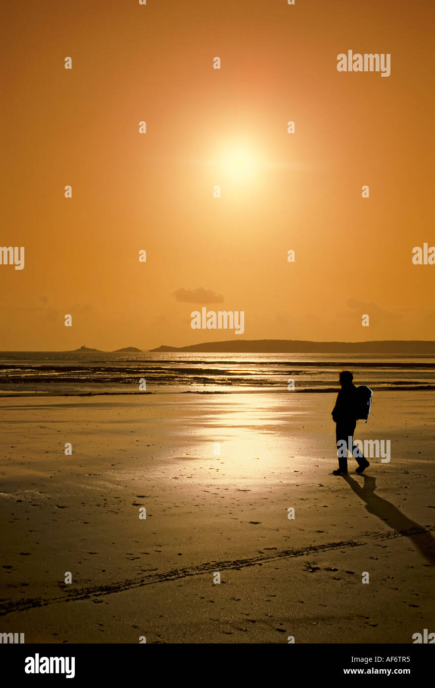 Frau Wanderer zu Fuß am Strand Swansea Bay mit der Mumbles Landzunge im Hintergrund Swansea Wales UK Stockfoto