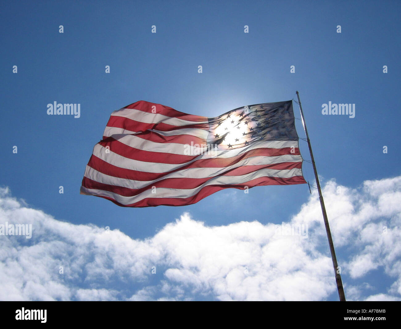 USA-Sterne und Streifen Nationalflagge gegen blauen Himmel mit weißen Wolken. Stockfoto