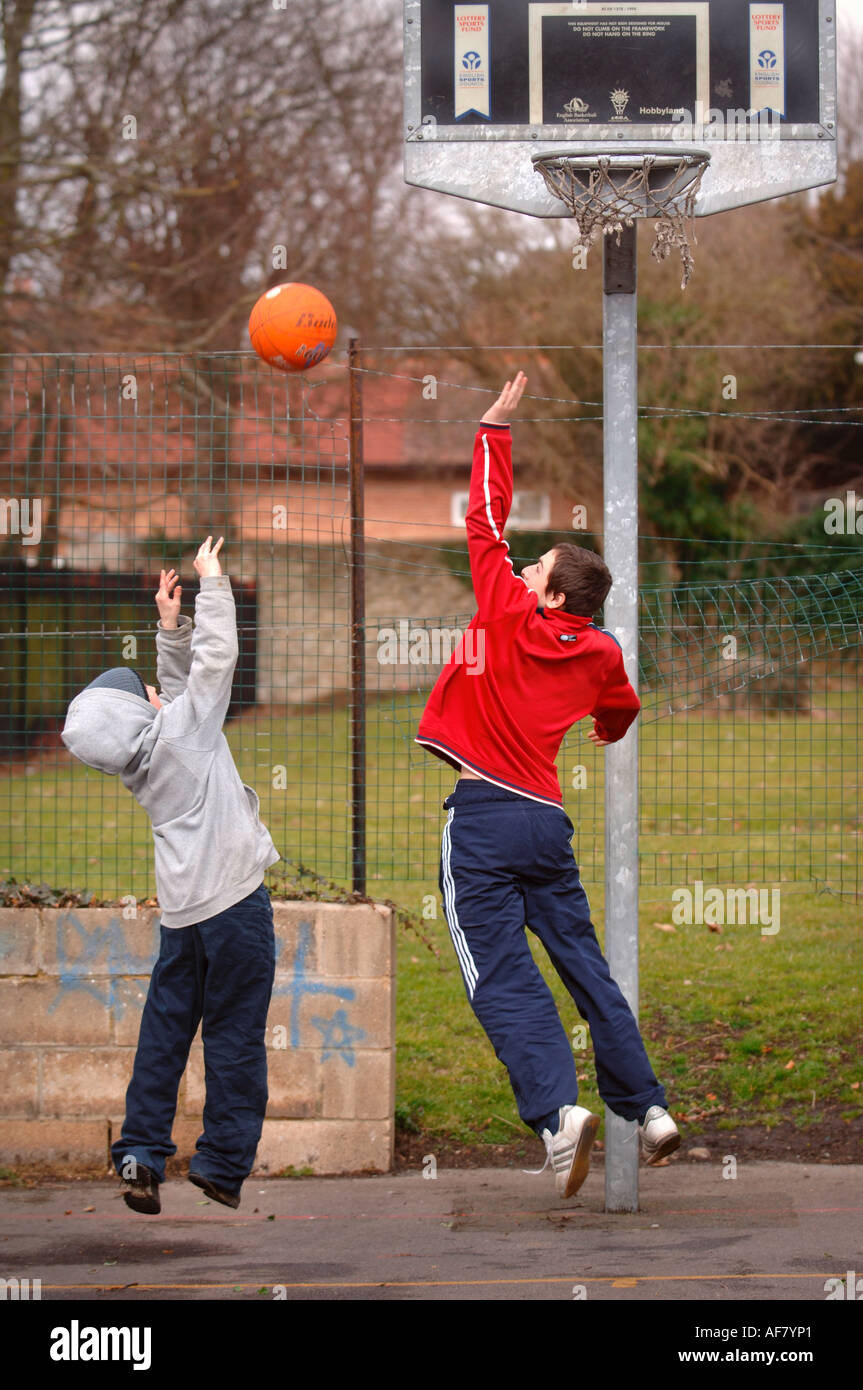 ZWEI JUNGS IM TEENAGERALTER SPIELEN BASKETBALL AUF EINE JUGEND CLUB UK ...