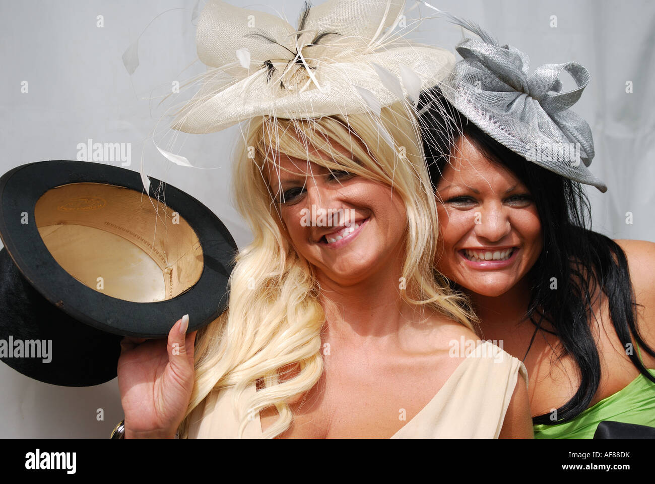 Junge Frauen mit Zylinderhut, Royal Ascot-Meeting, Ascot Racecourse, Ascot, Berkshire, England, Vereinigtes Königreich Stockfoto