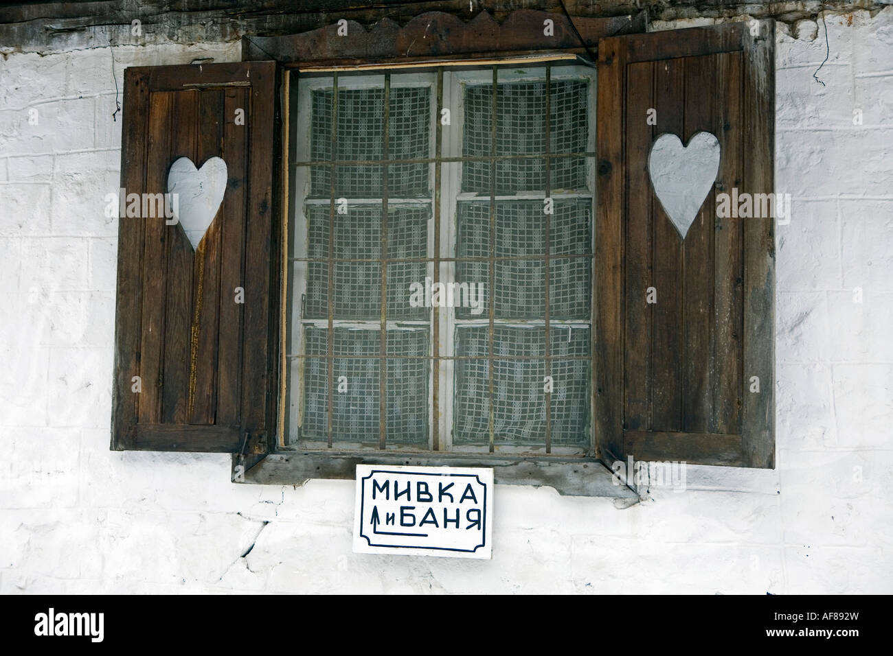 Ein Fenster mit Fensterläden und zwei Herzen, zeigt die Zeichen eine Dusche und eine Badewanne, bulgarische Hutromance, Demjanica Hütte, Pirin Mounta Stockfoto