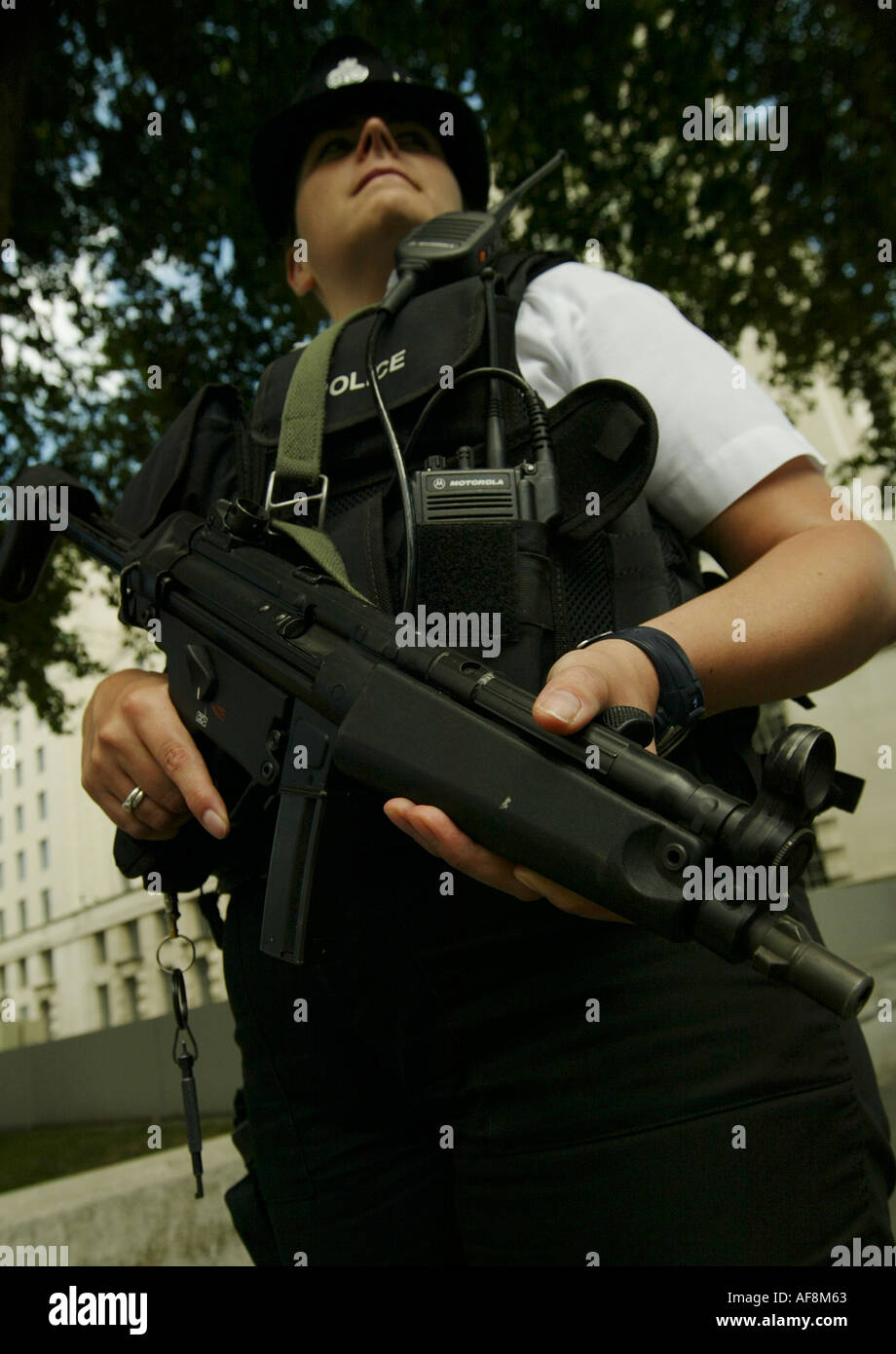 Eine Polizistin bewaffnet steht Wache außerhalb des Verteidigungsministeriums Whitehall London Stockfoto
