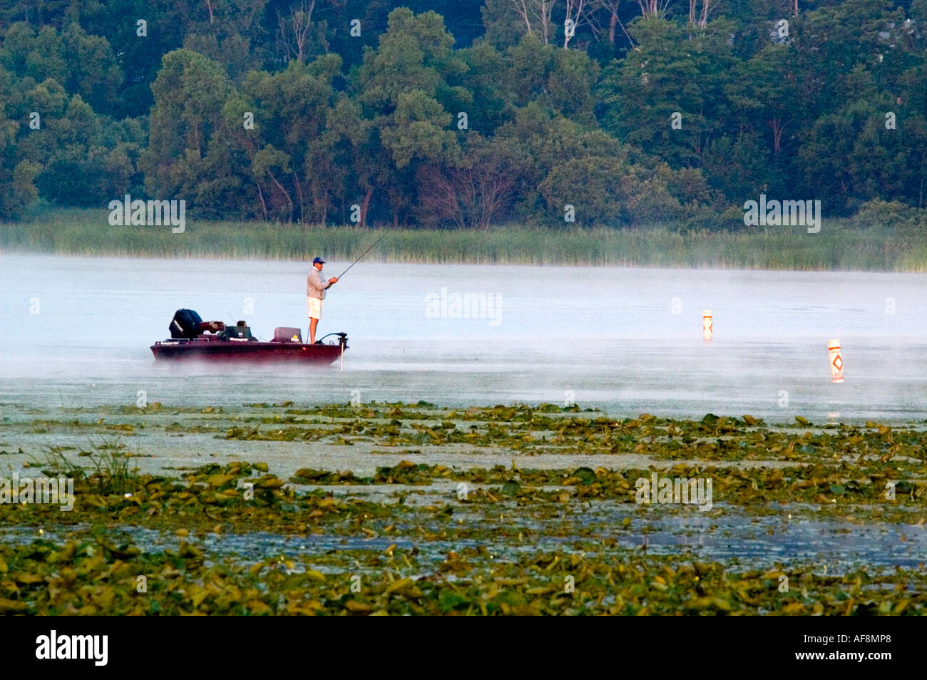 Fischer versucht sein Glück in den frühen Morgenstunden auf einem Nebel bedeckt White Lake in der Nähe von Montague MI Stockfoto
