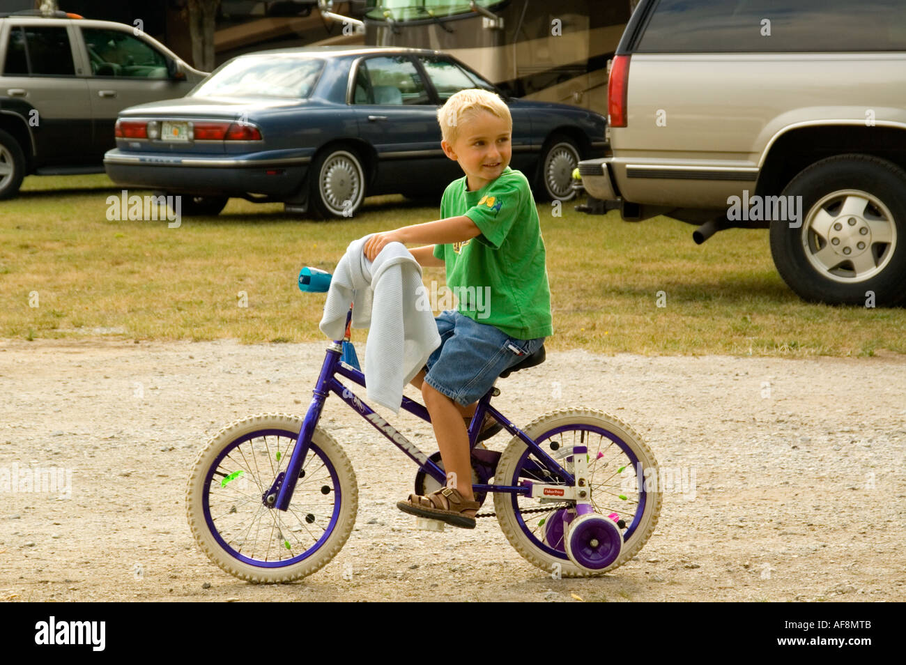 Während seine Lieblingsdecke greifen lernt ein vier Jahre alter Junge, mit dem Fahrrad auf einem RV Park in Montague MI USA Stockfoto