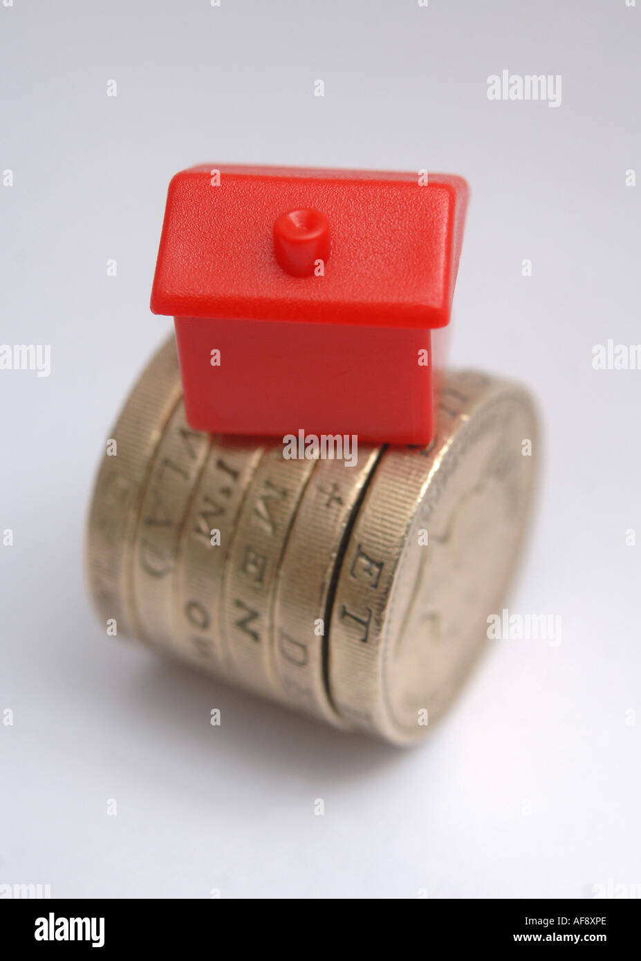 Ein Monolopy Haus auf Münzen zu Haus-Preis und Zinssatz-Änderungen zu veranschaulichen Stockfoto