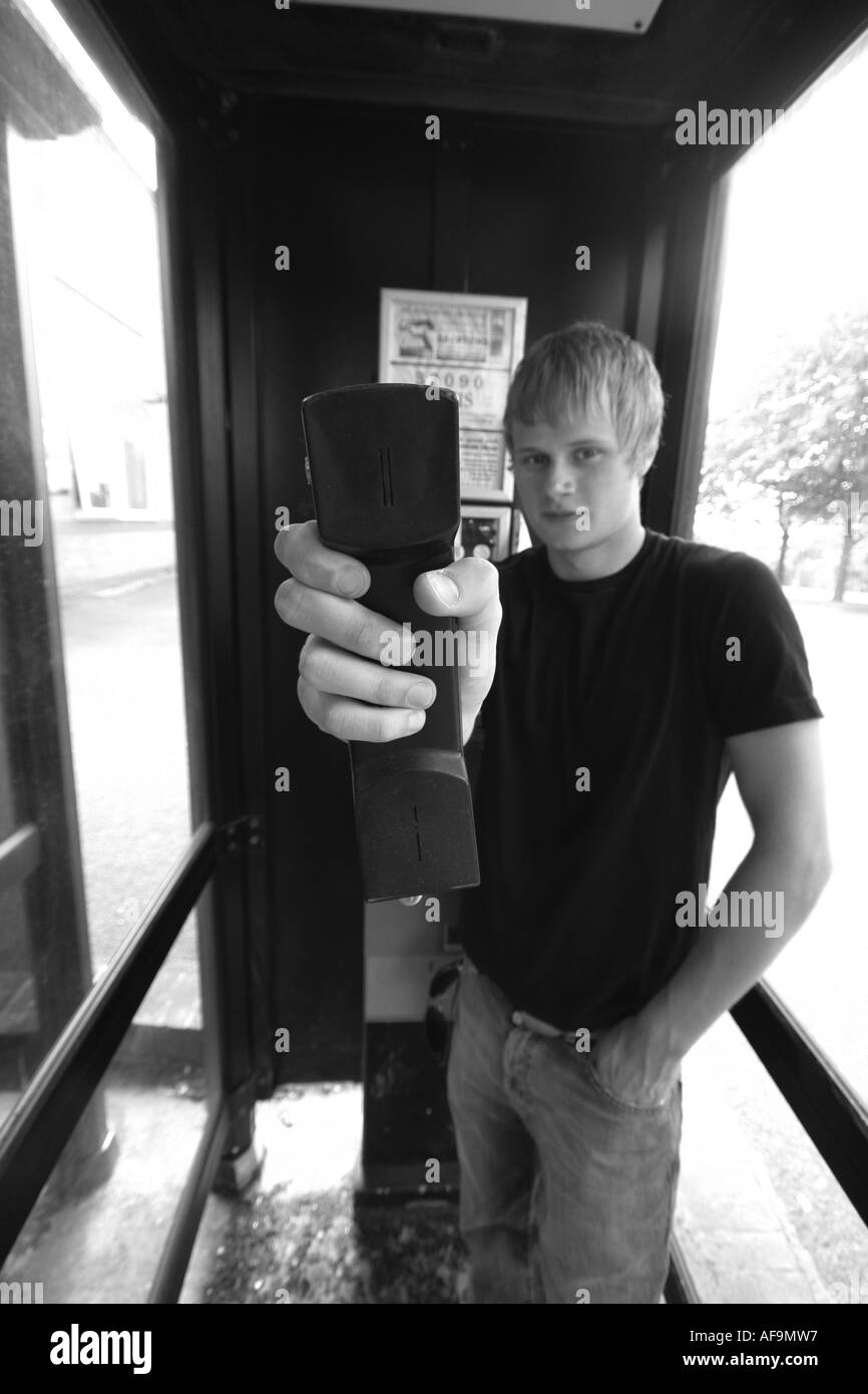 Ein Stock Foto eines Schülers auf eine traditionelle Telefonzelle Stockfoto