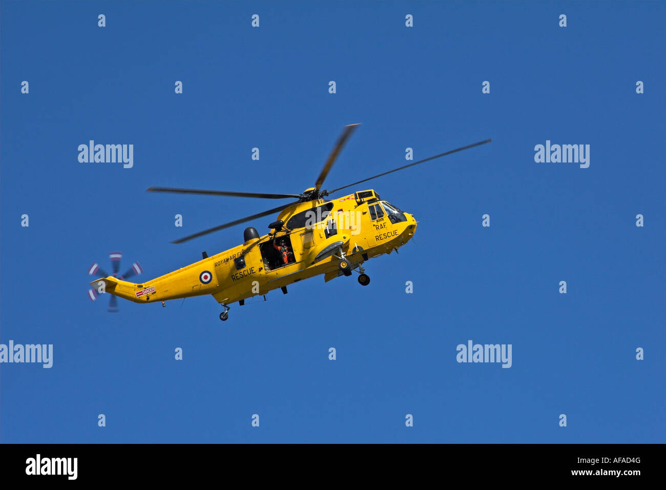 Ein RAF Suche und Rettung Hubschrauber fliegen (Küstenwache) in North Devon, England mit blauem Himmel Stockfoto