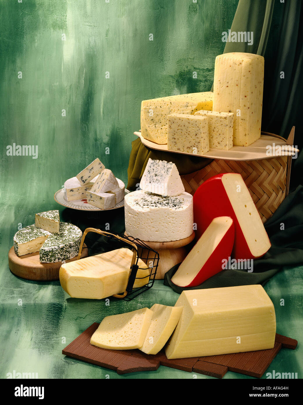 Dänischer Käse in Gruppe Farbfoto auf grün getönten gesprenkelte Hintergrund. Hochformat, Studio Tischplatte. Klassisches Bild Stockfoto