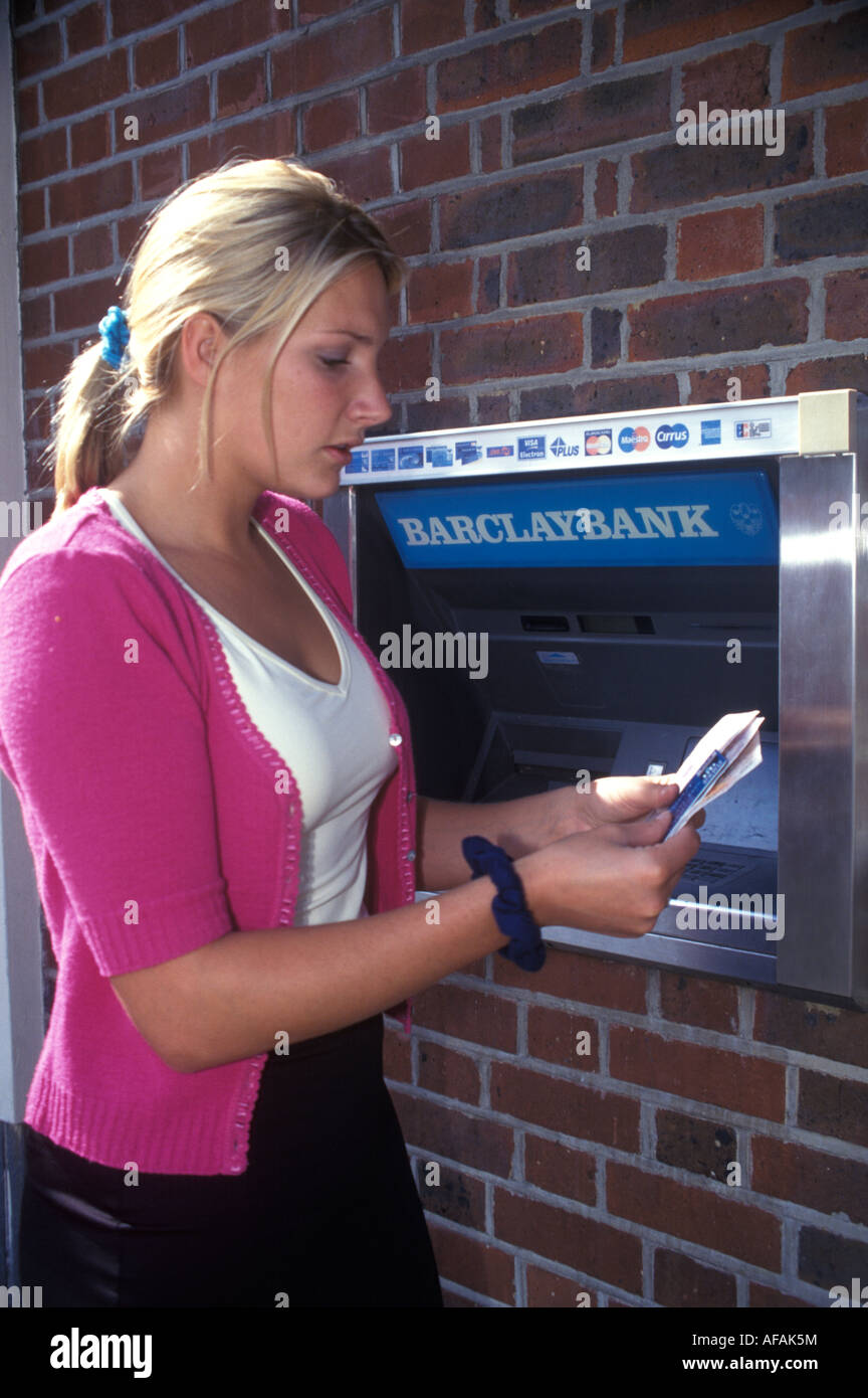 Frau bekommen Geld von Geldautomaten in der Wand Stockfoto