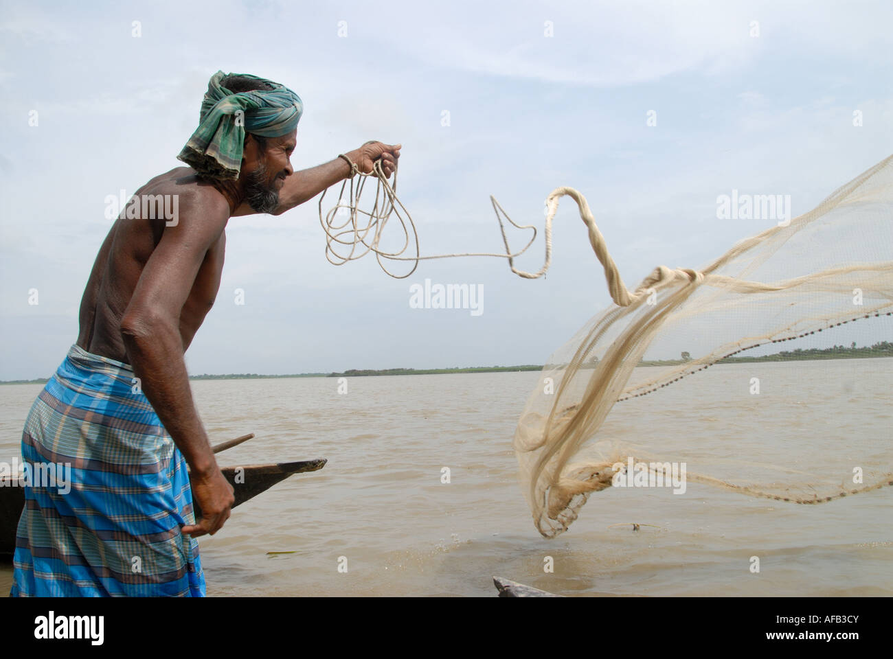 Bangladesch 2007 nach der Flut. Jigamarighat Buduz Samon 40 Fischer wirft sein Netz Stockfoto