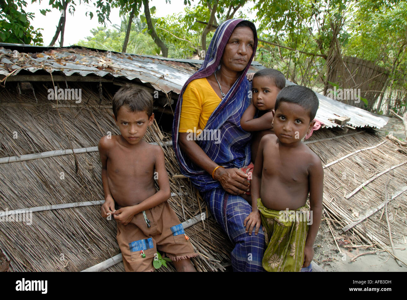 Bangladesch 2007 nach der Flut.  Großmutter mit eingestürzten Haus und Enkel Stockfoto