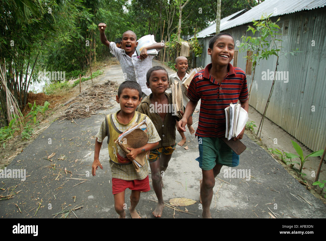 Bangladesch 2007 nach der Flut.  Jungen eilen zur Schule tragen ihre Schulbücher. Stockfoto