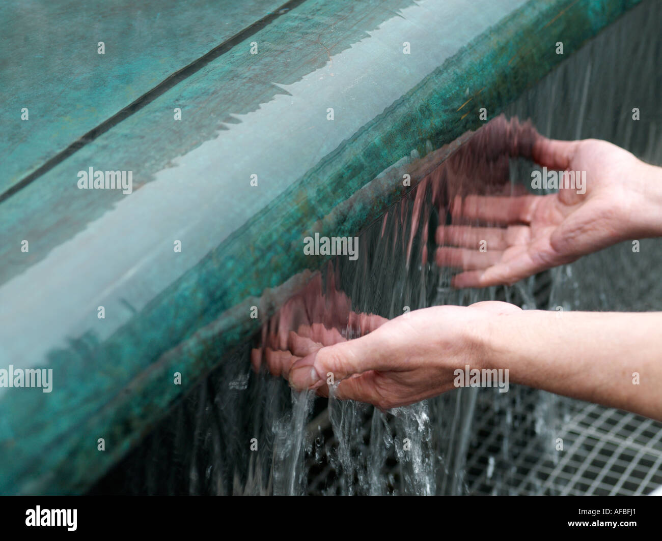 Hände unter ein Wasserspiel Stockfoto