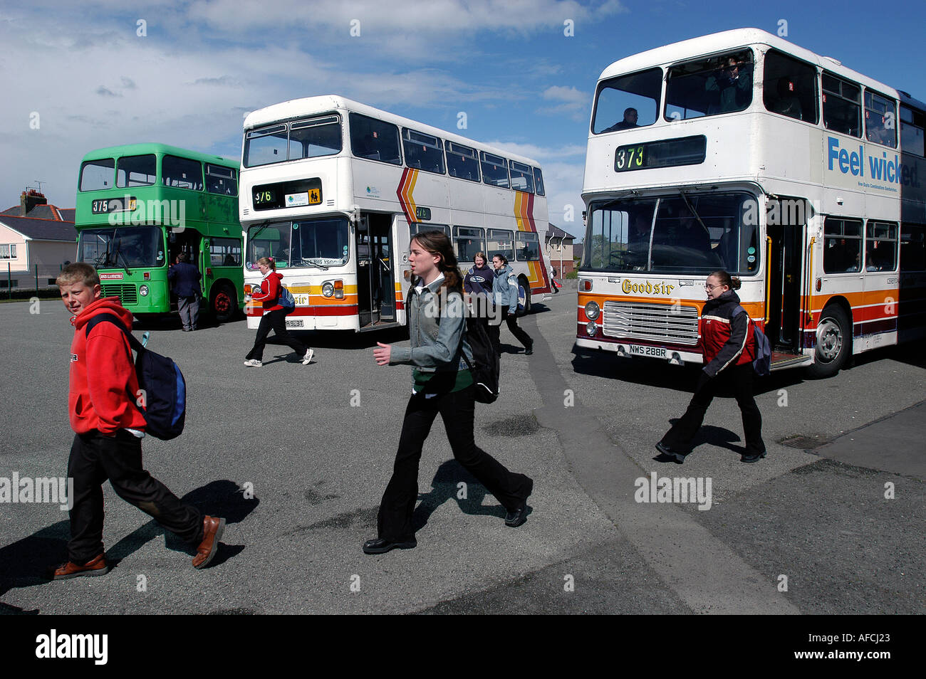Schülerinnen und Schüler kommen in der Schule auf den Schulbus, UK. Stockfoto