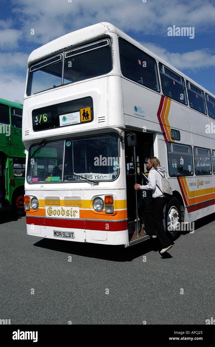 Schülerinnen und Schüler einsteigen in einen Schulbus, UK. Stockfoto
