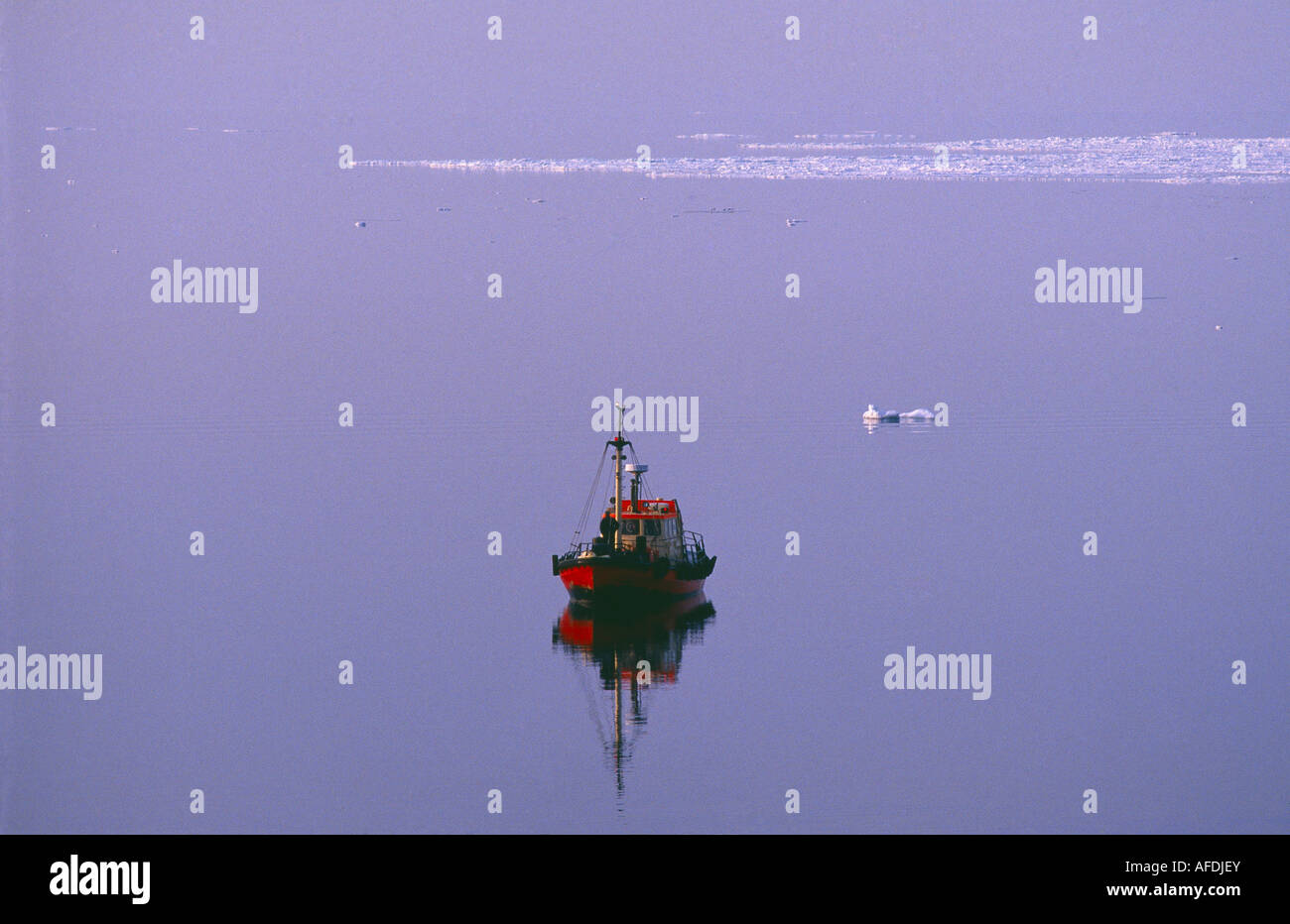 ein Lotsenboot an der flachen ruhigen Ostsee mit einer Eisscholle vor der Küste Finnlands, Ostsee Stockfoto