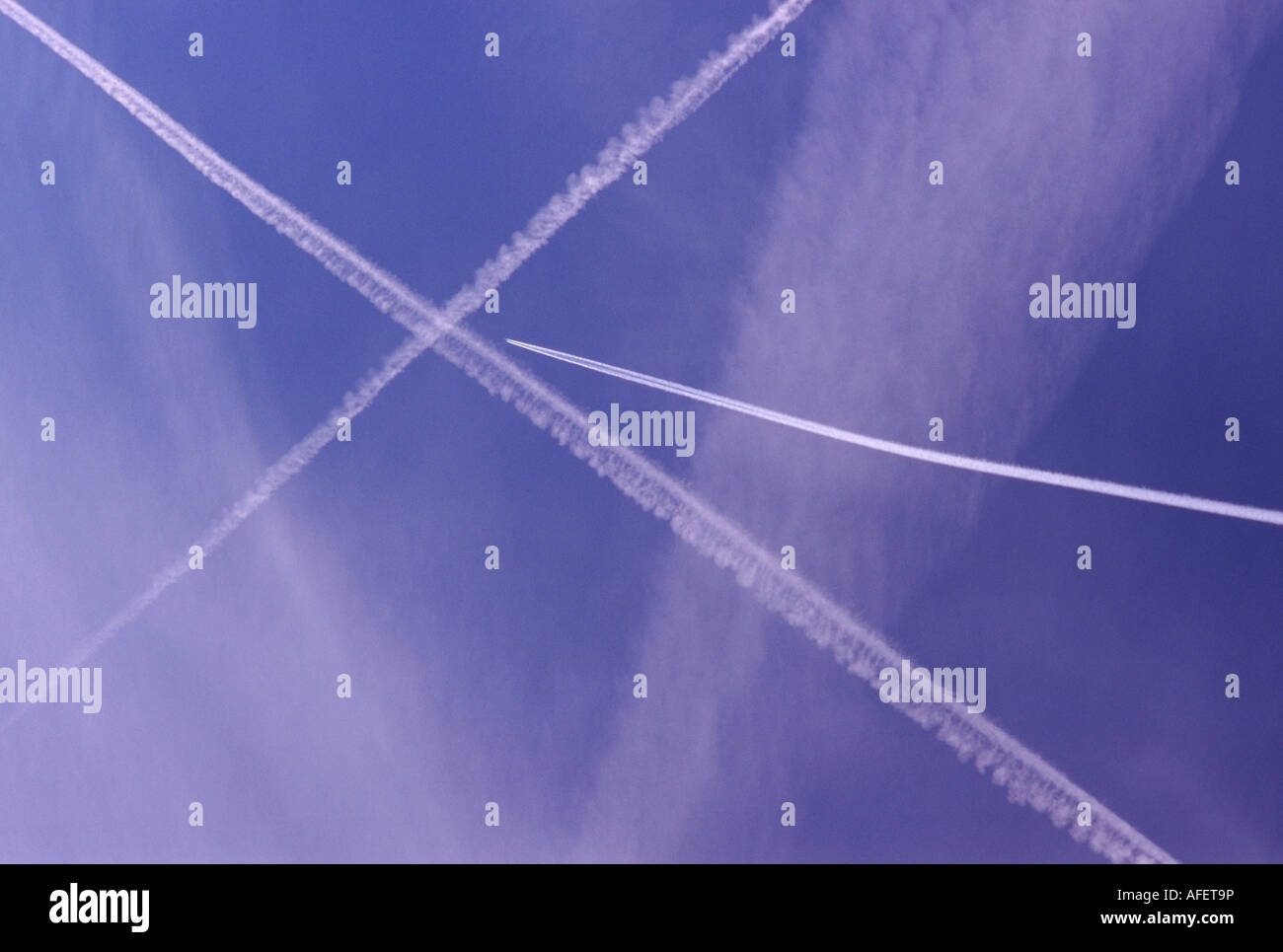 Ziel 3: Jet konvergierenden am Schnittpunkt von zwei weißen Kondensstreifen bilden ein X vor einem blauen Himmel. Stockfoto
