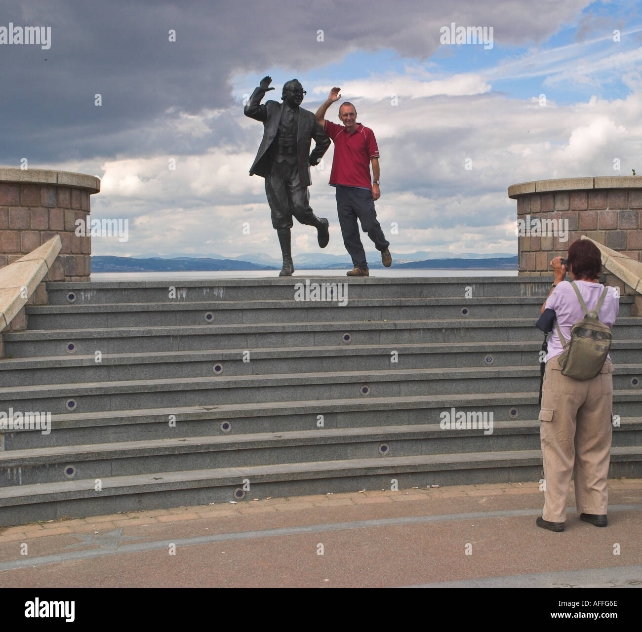 Ein Tourist hat seine mit Statue von Eric Morecambe fotografieren. Morecambe, Lancashire, Großbritannien Stockfoto