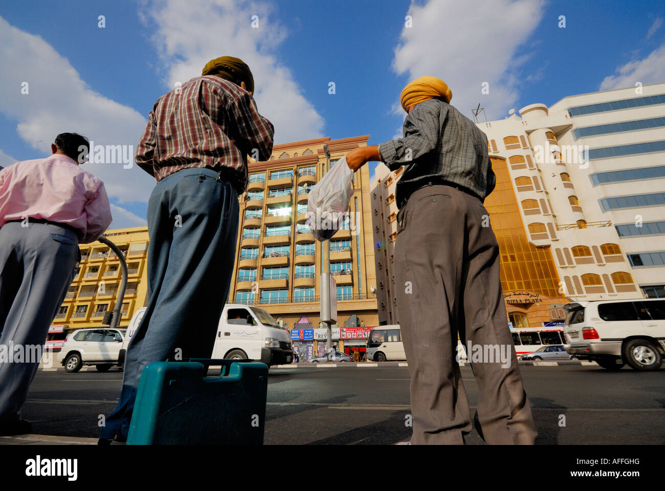 indische Arbeiter warten an der Bushaltestelle, Dubai City, Vereinigte Arabische Emirate Stockfoto