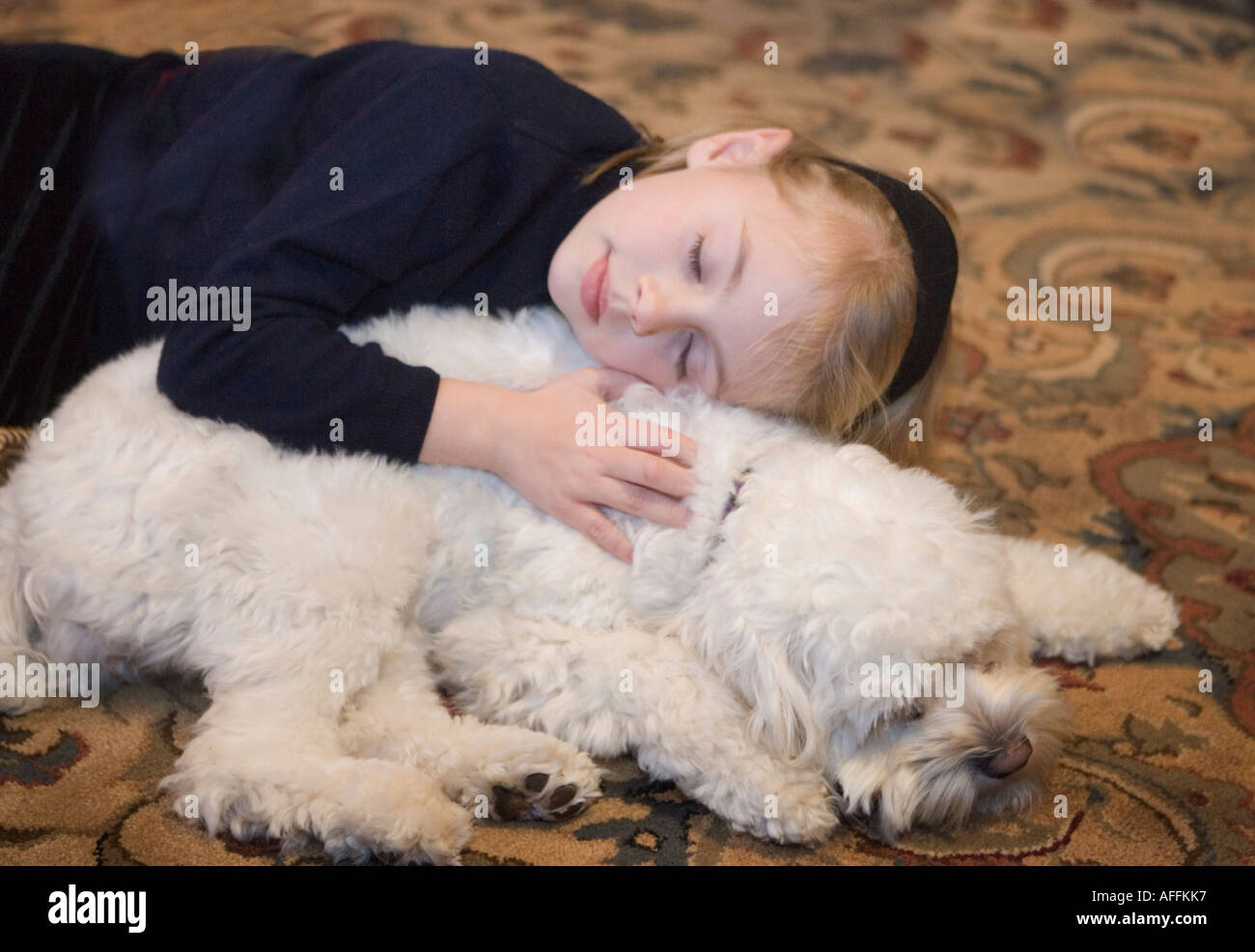 Kind und ihr Hund umarmt Stockfoto