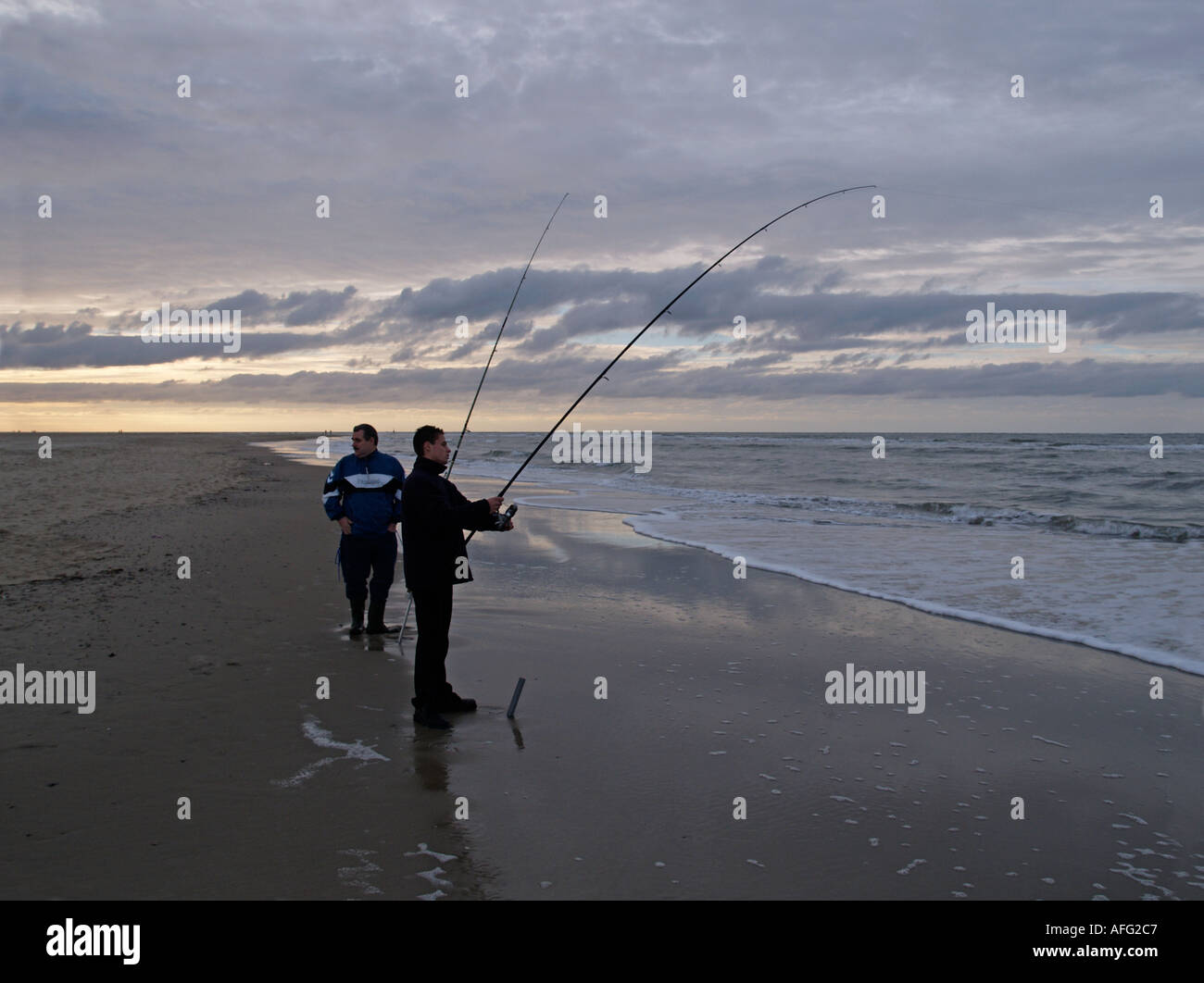 Zwei Sport-Fischer an der Nordsee-Küste der Insel Texel Noord Holland Niederlande Stockfoto