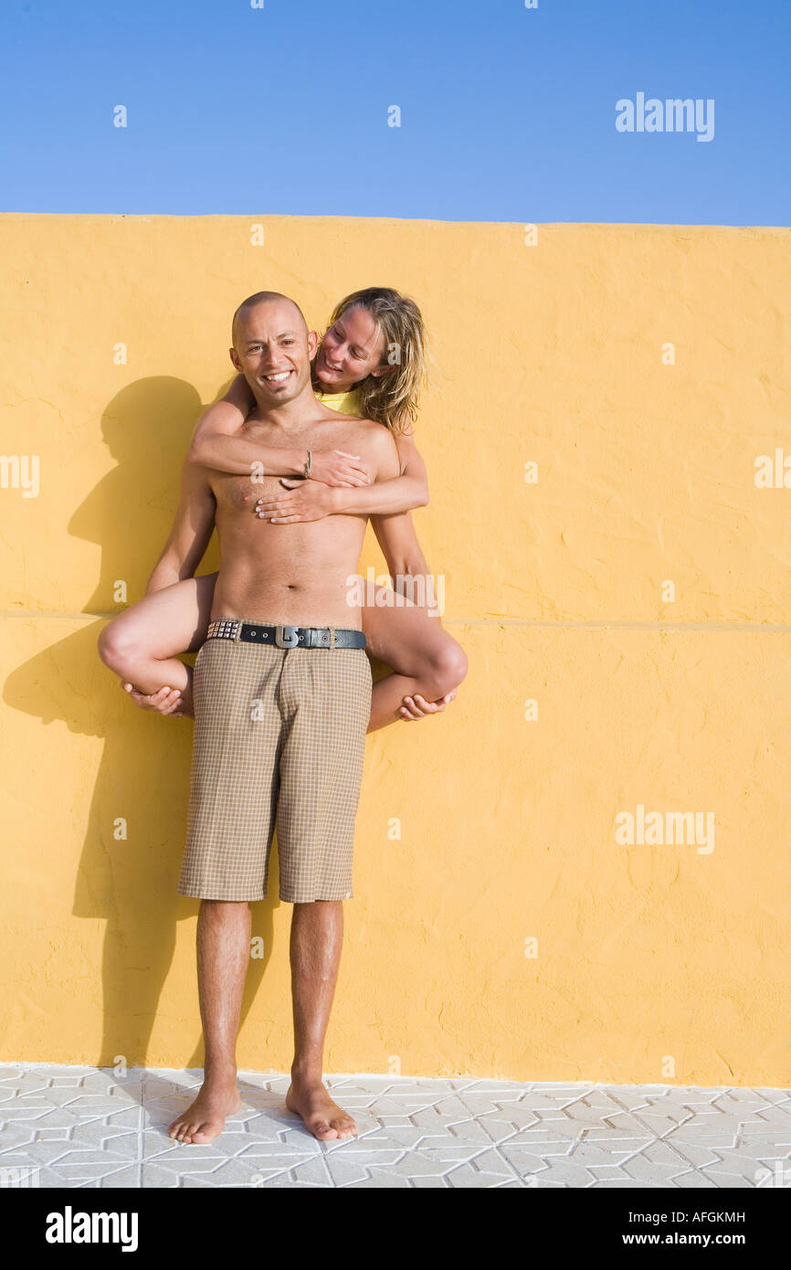 Romantisches paar gelbe Wand gelehnt Stockfoto