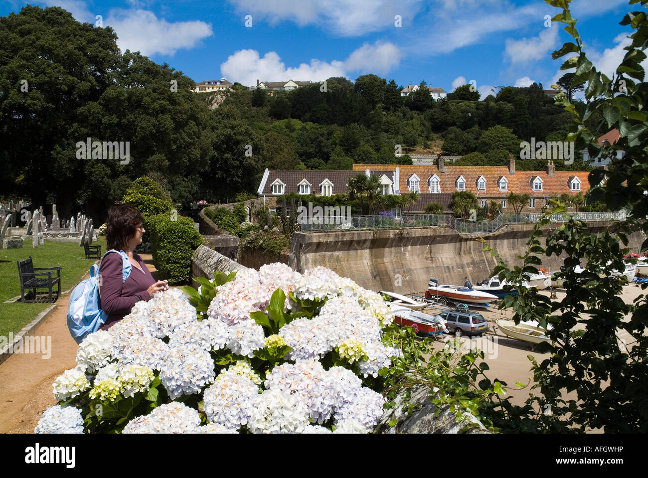 dh St Brelades Bay ST BRELADE JERSEY Frau touristischen Blick über Deich und Blumen Stockfoto