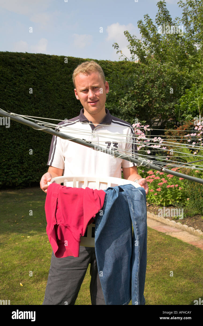 Ein junger Mann zu hängen, seine frisch gewaschen Wäsche. Stockfoto